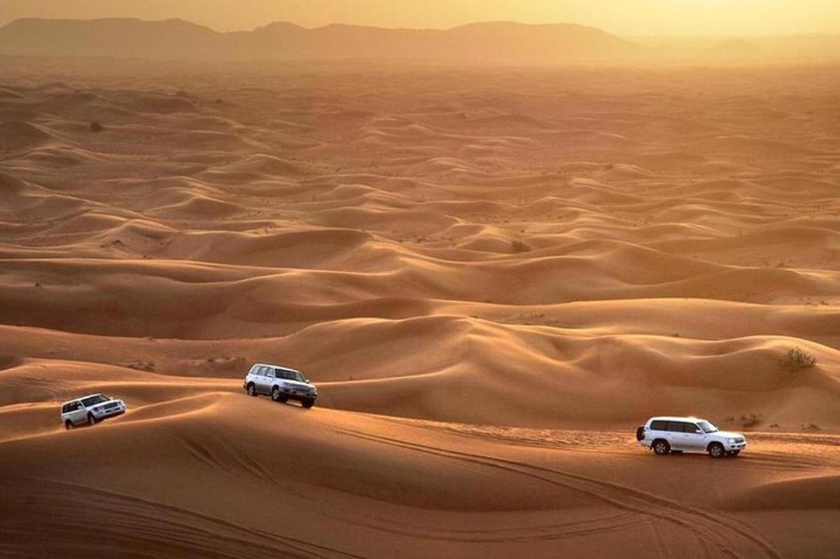 three cars driving in the desert