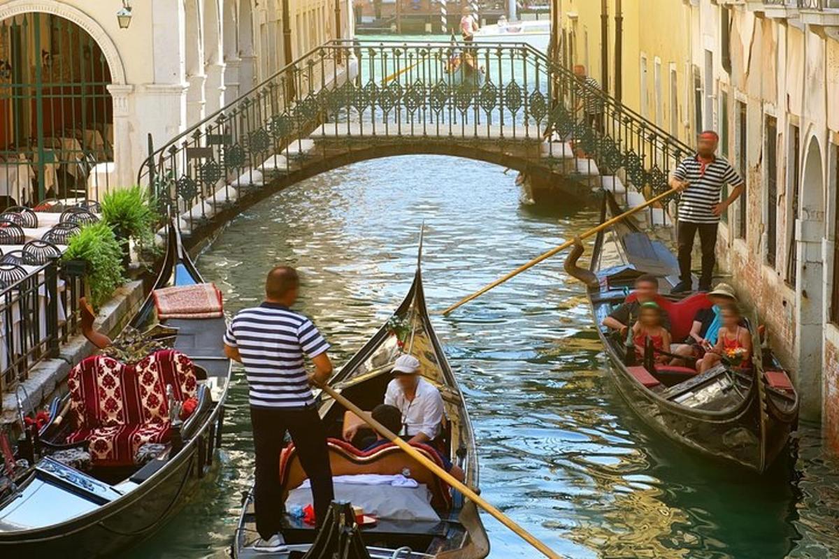 a group of people riding gondolas down a canal