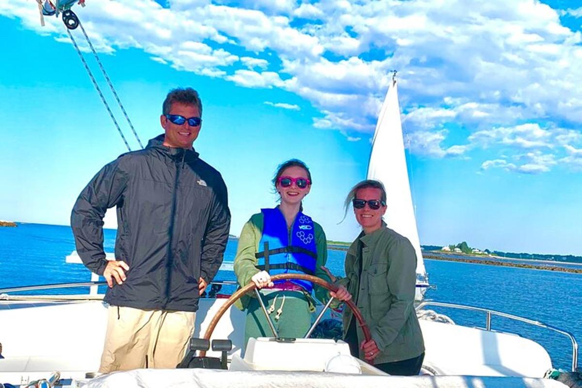 three people standing on a boat in the water