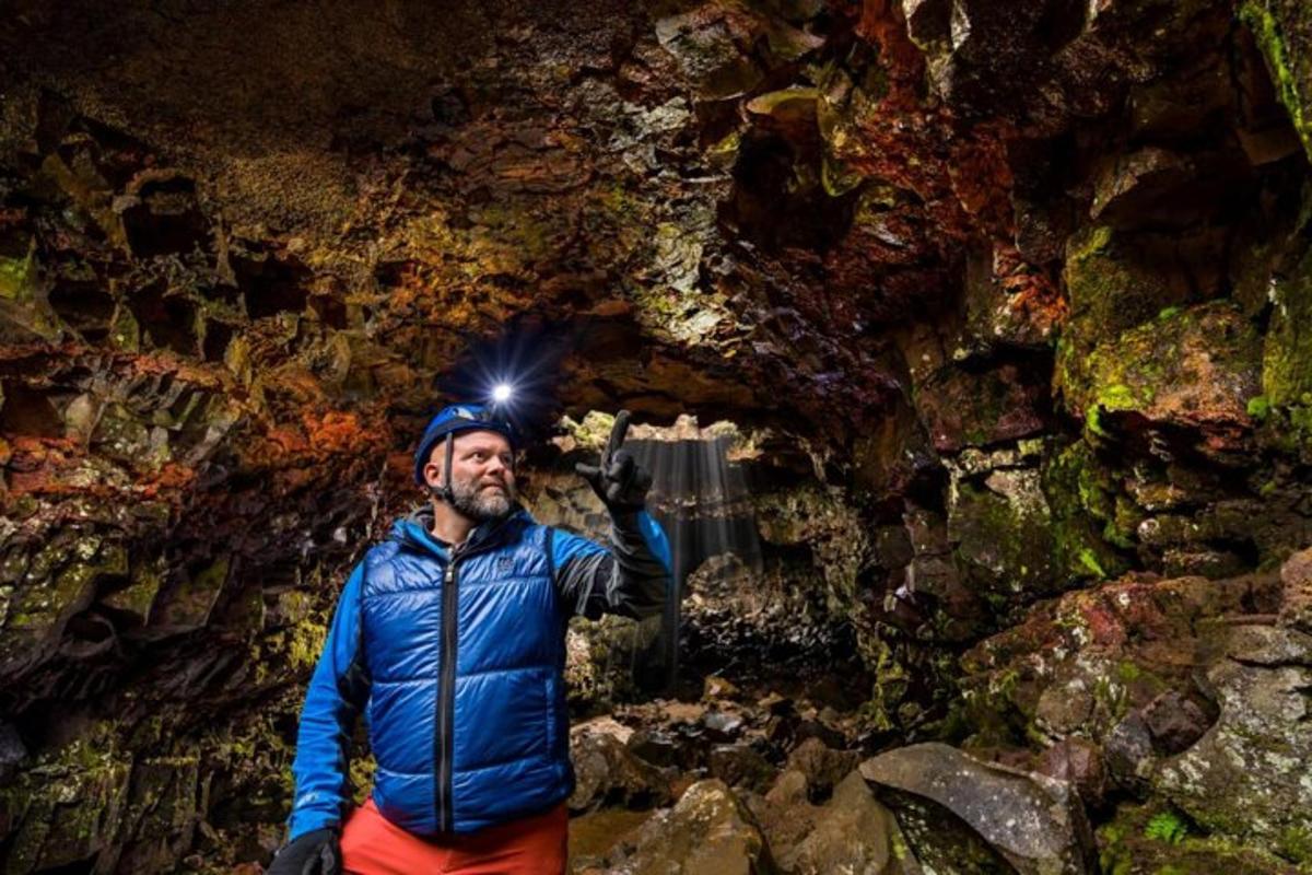 a man with a camera on his head in a cave