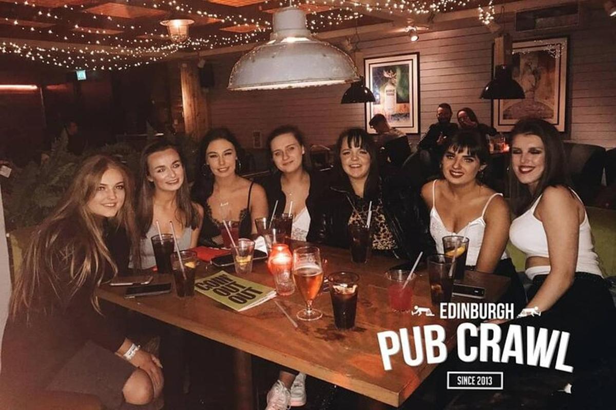hópur fólks situr við borð á bar