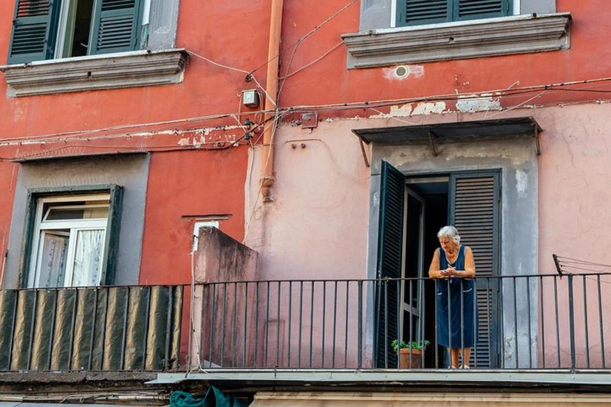 una donna in piedi sul balcone di un edificio