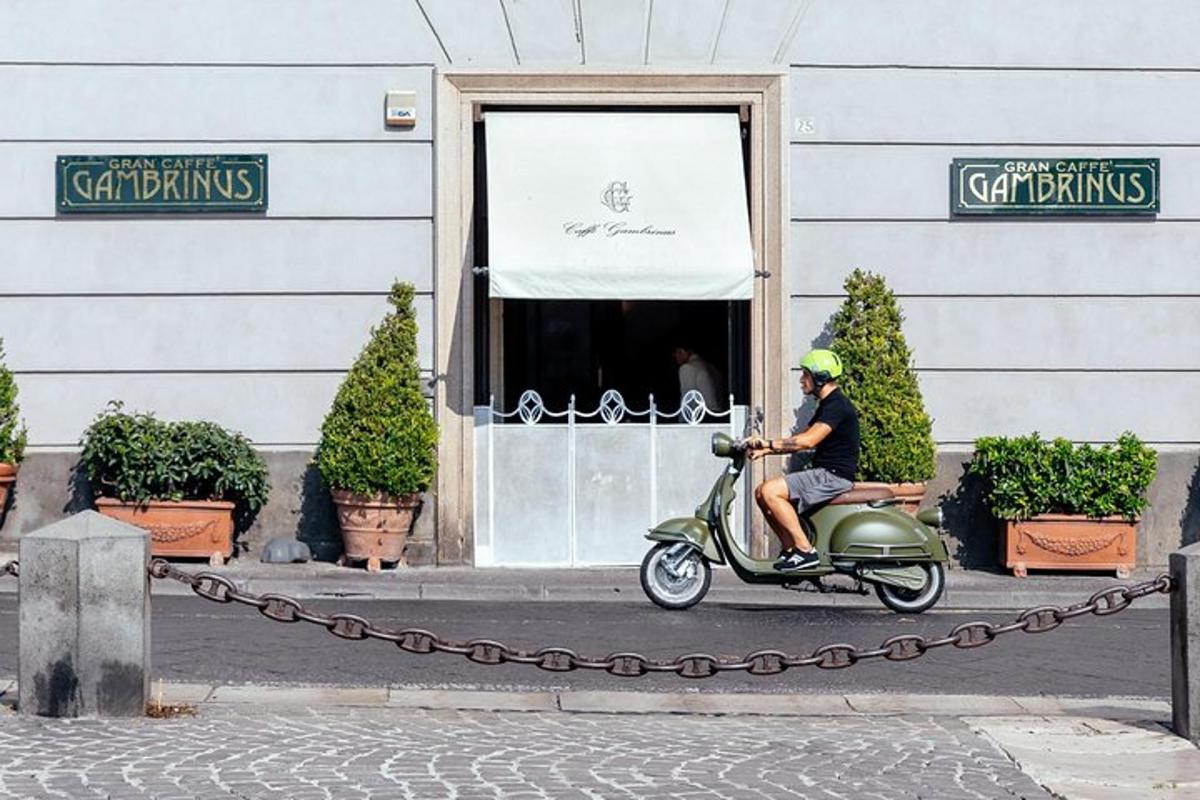 un uomo in sella a uno scooter davanti a un edificio