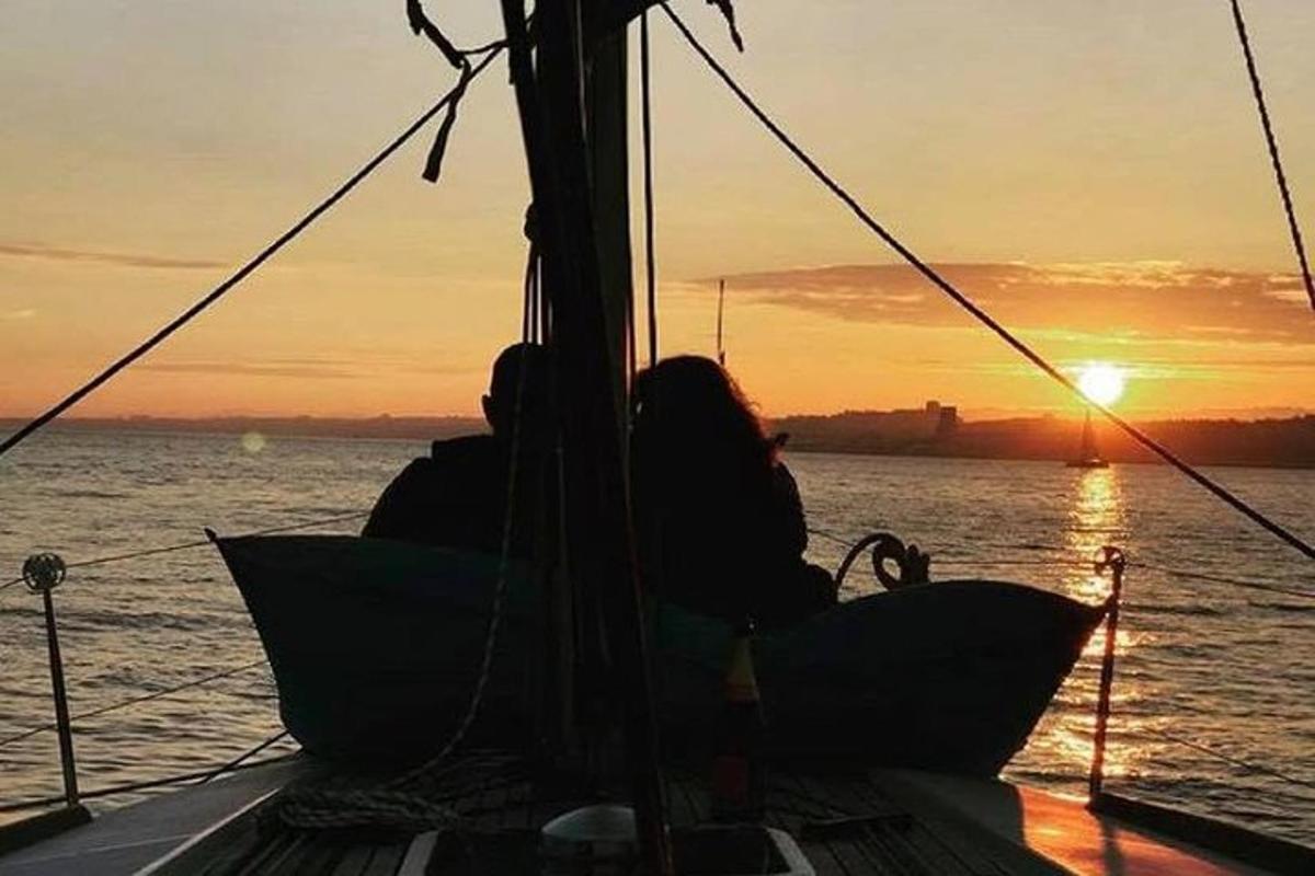 Μια ομάδα ανθρώπων που κάθονται σε μια βάρκα στο ηλιοβασίλεμα