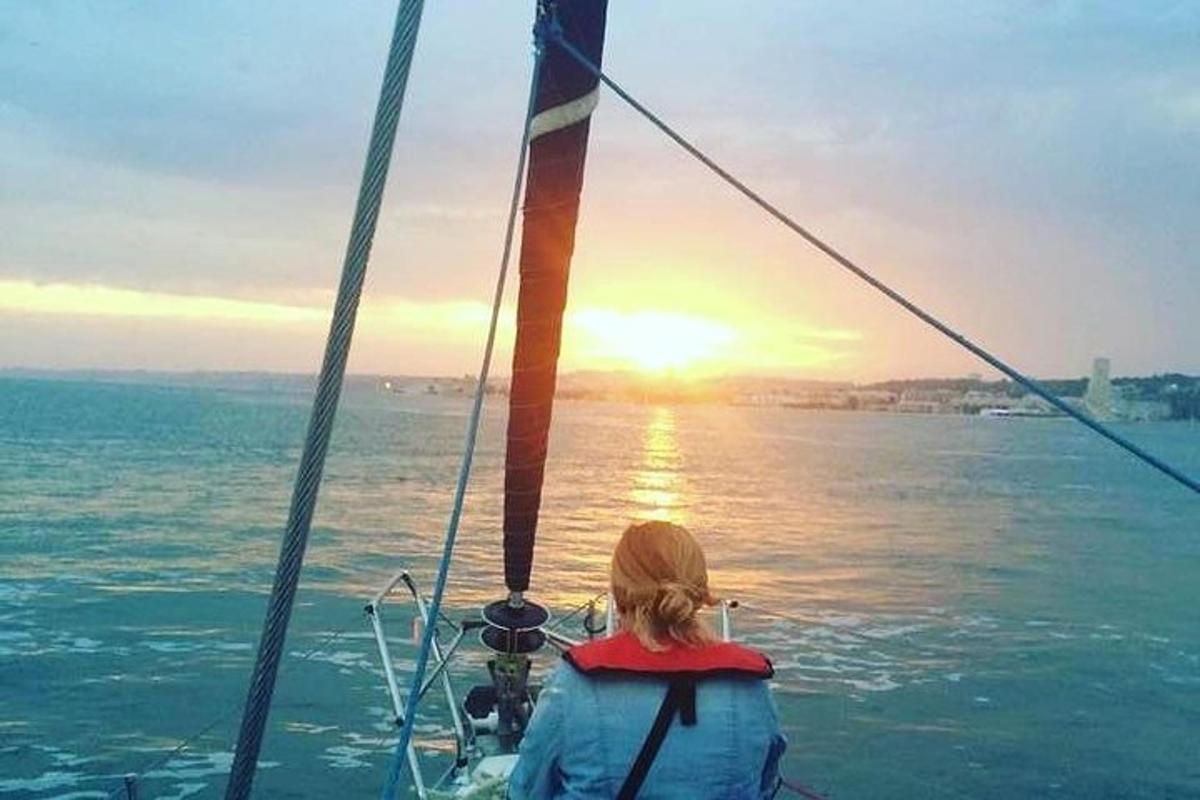 isang babae sa isang bangka na nakatingin sa paglubog ng araw