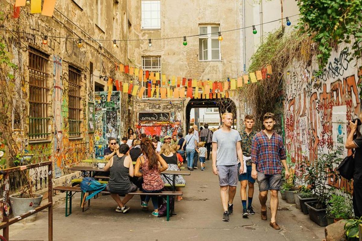 skupina lidí procházejících uličkou s graffiti