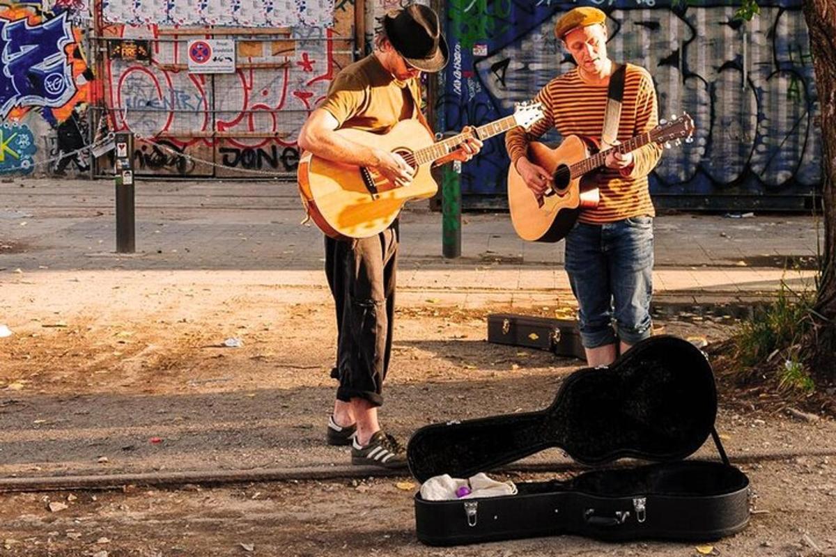 to mænd spiller musik på gaden med guitarer