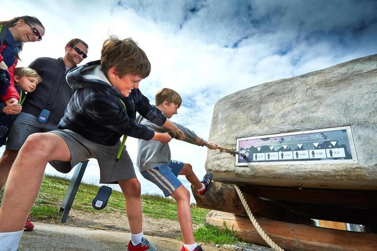 um grupo de meninos puxando uma pedra com uma corda