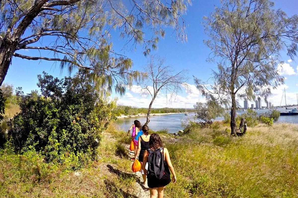 a group of people walking down a trail near a river