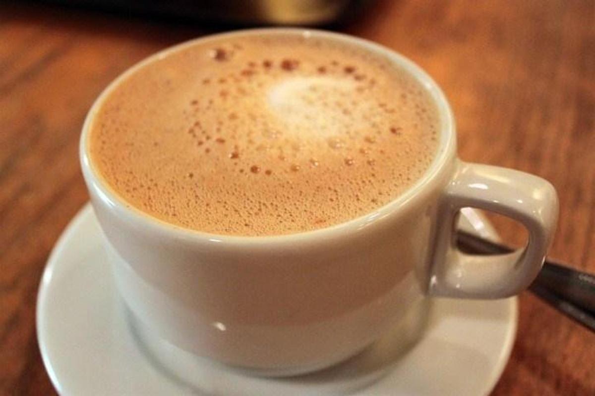 una tazza di caffè appoggiata su un piatto su un tavolo