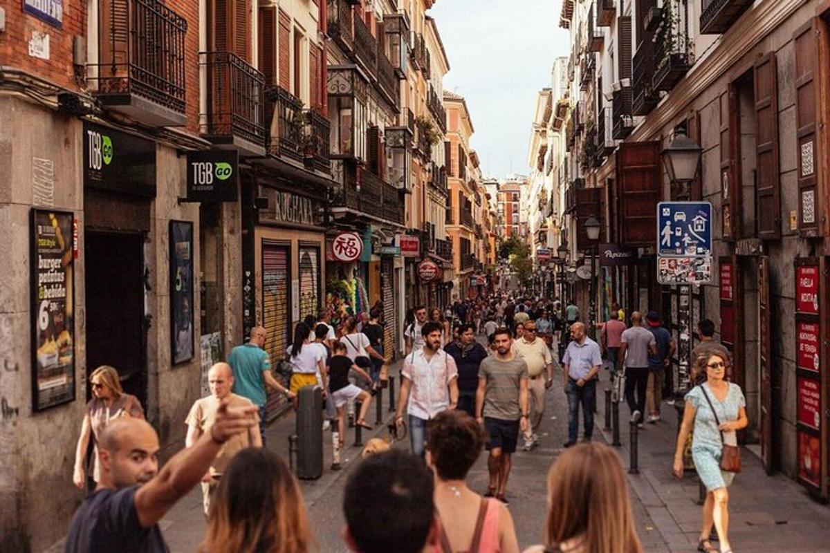 una folla di persone che camminano lungo una strada con edifici