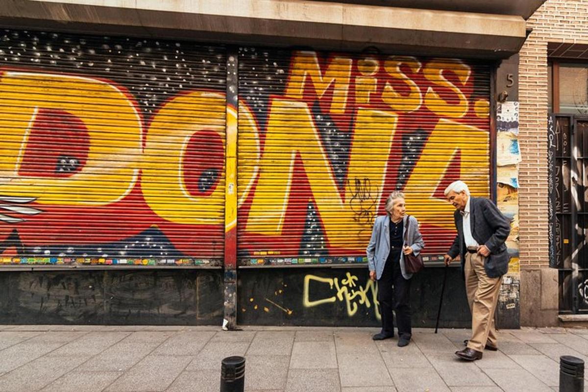 un uomo e una donna in piedi davanti a un muro con graffiti