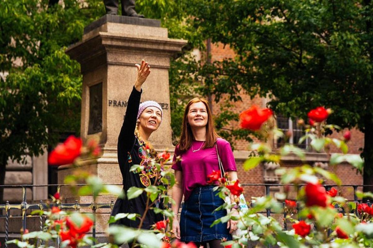 zwei Frauen stehen vor einem Denkmal mit Rosen