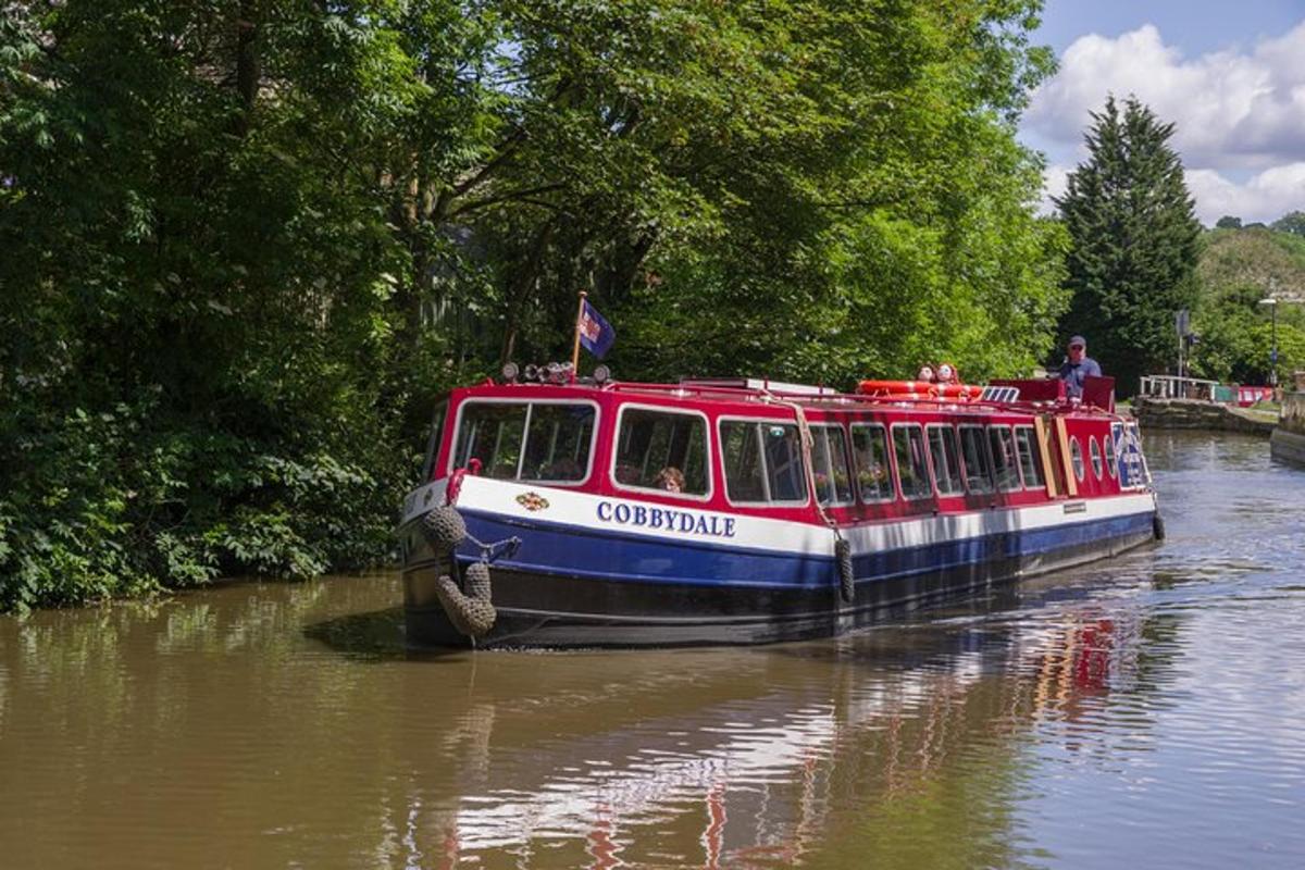 a red and white boat traveling down a river