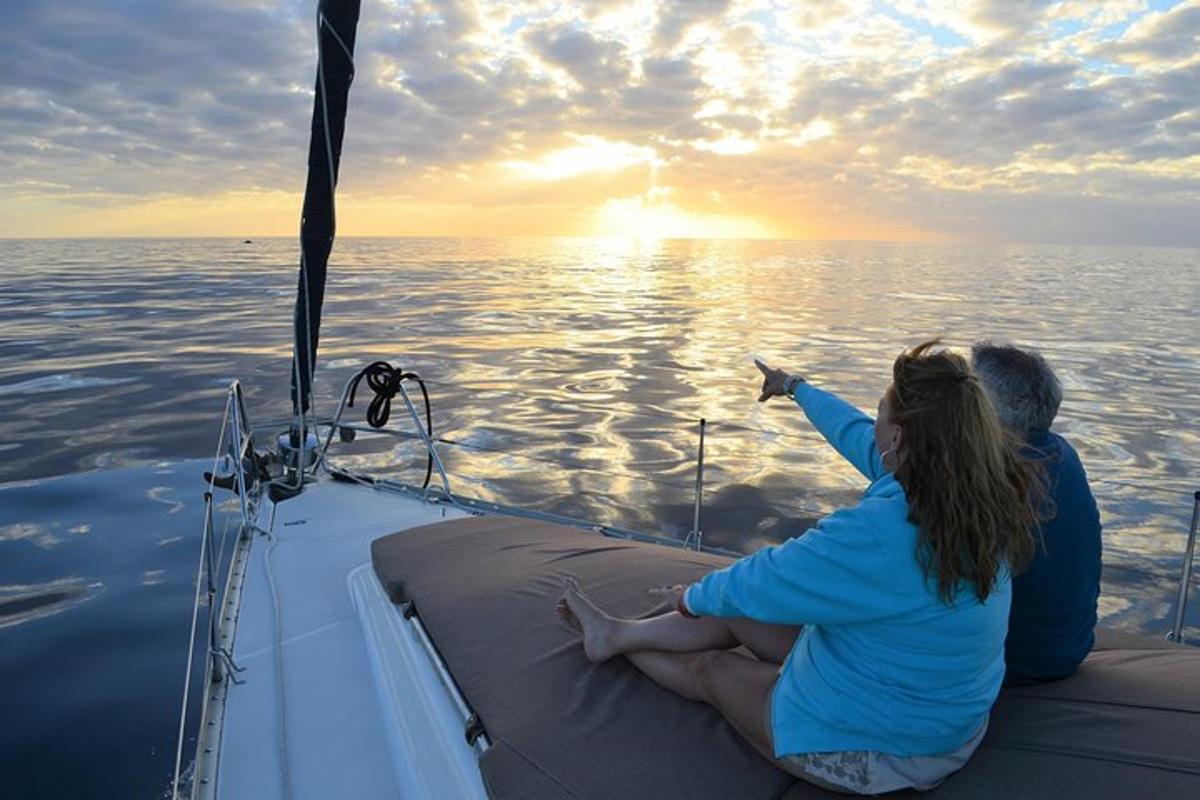 two people sitting on the back of a boat in the water