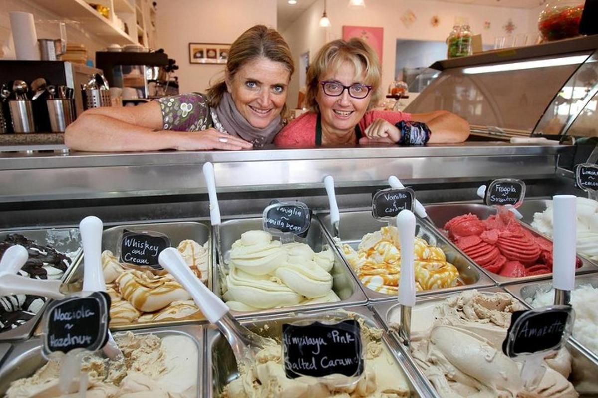 two women standing behind a counter in a bakery