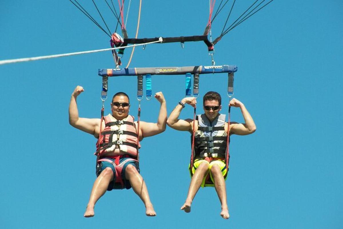 two men are riding on a tandem parachute