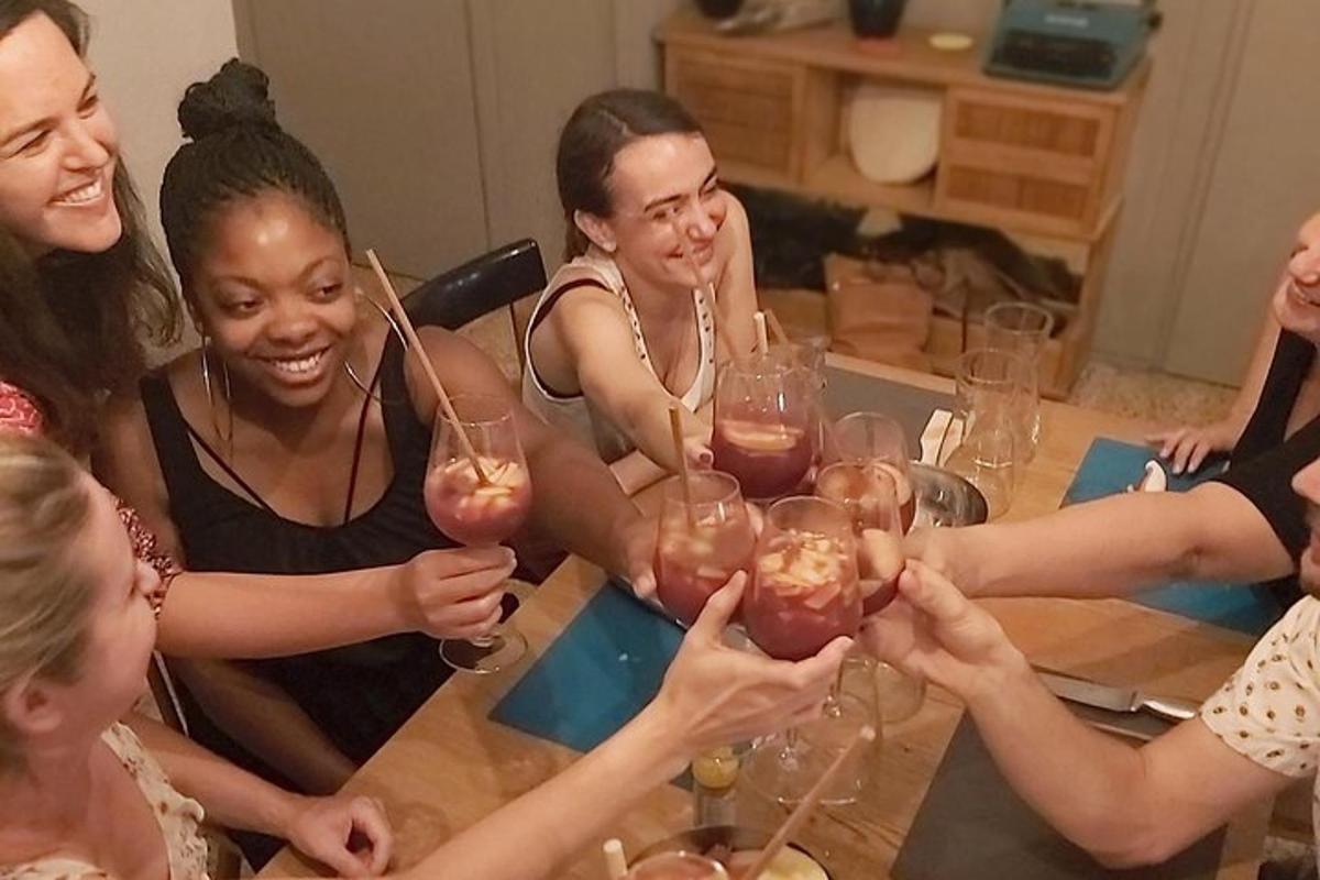 a group of women sitting around a table holding wine glasses