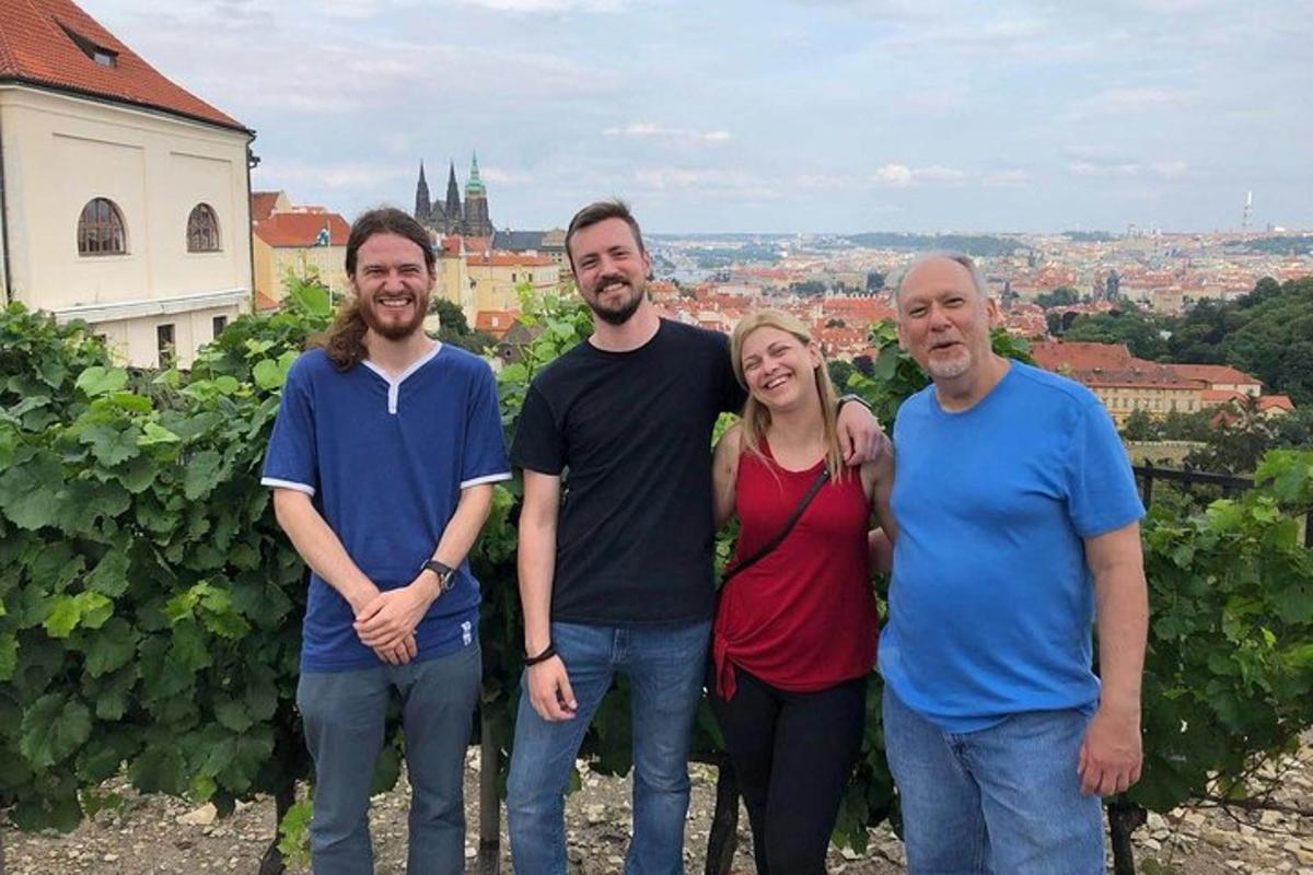 cilvēku grupa, kas pozē fotografēšanai vīna dārzā