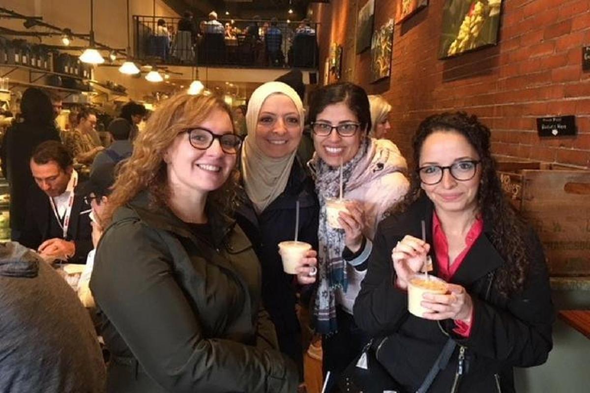 quattro donne posano per una foto mentre tengono in mano dei drink
