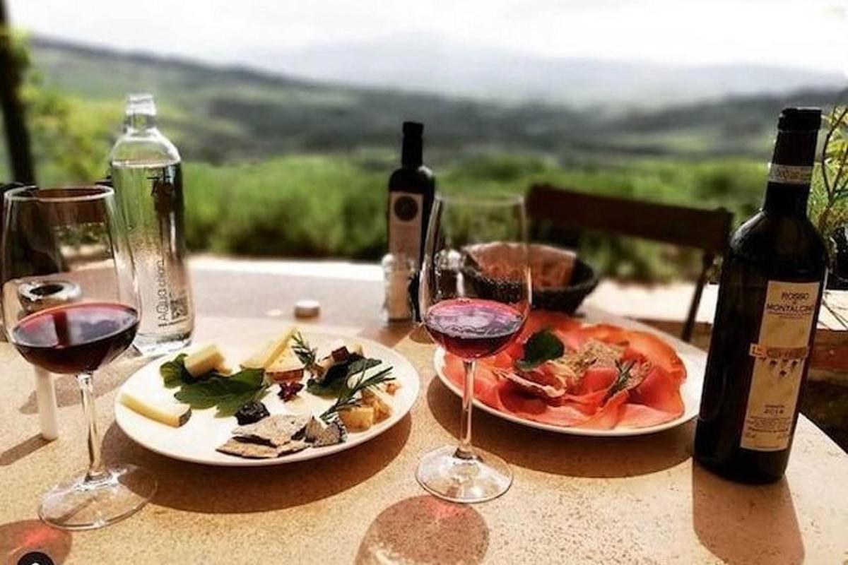 Una mesa con dos platos de comida y copas de vino.