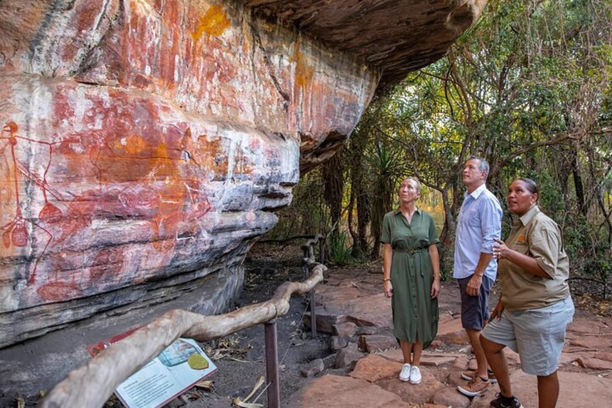 three people standing in front of a rock wall