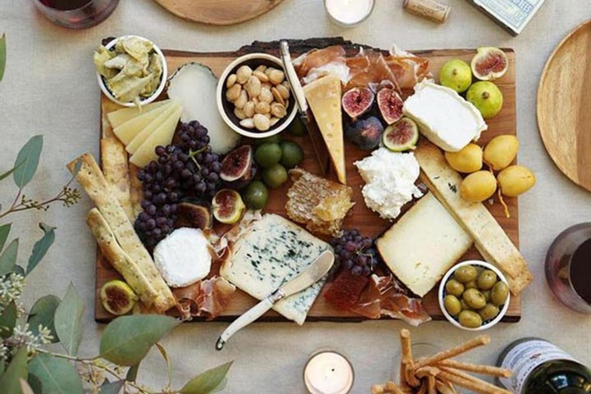 a cutting board filled with cheese and other foods