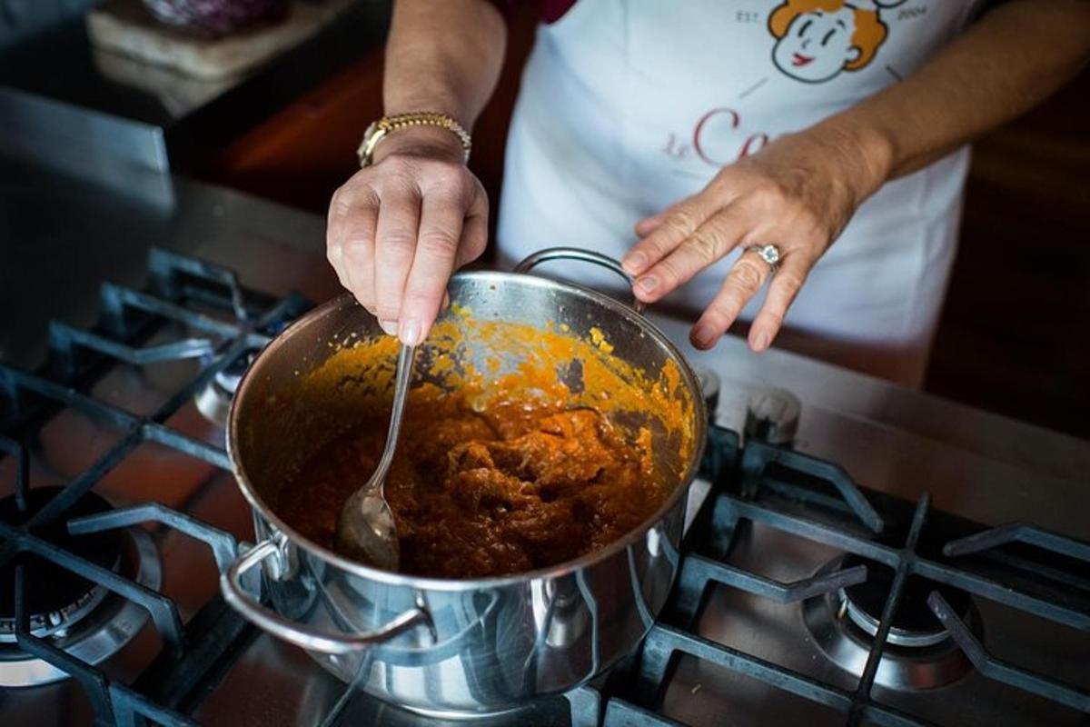 seseorang mengaduk makanan dalam panci di atas kompor