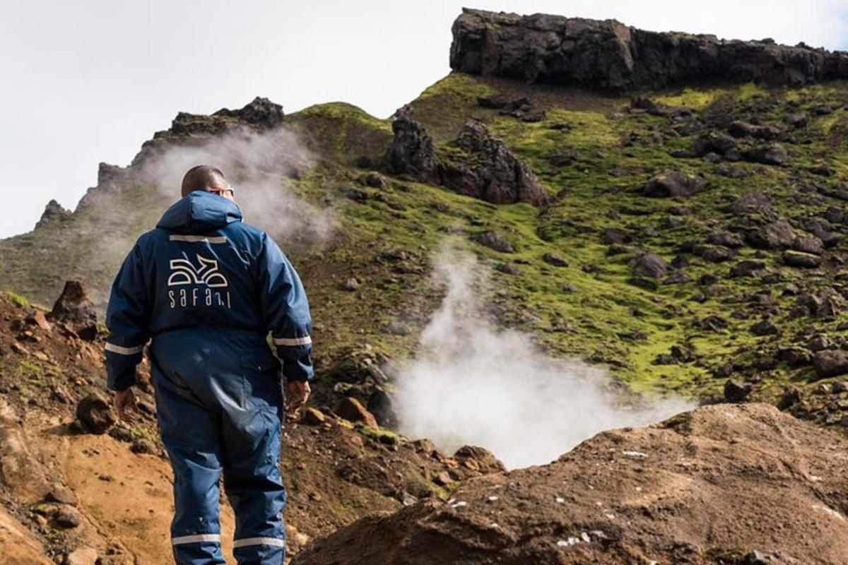 Un hombre parado en la cima de una montaña con aume