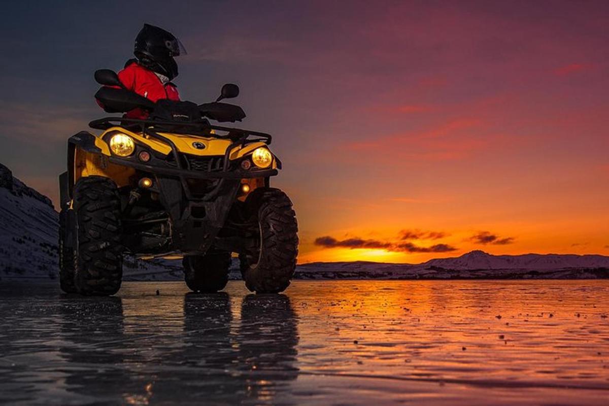 una persona in sella a una moto da cross in acqua al tramonto