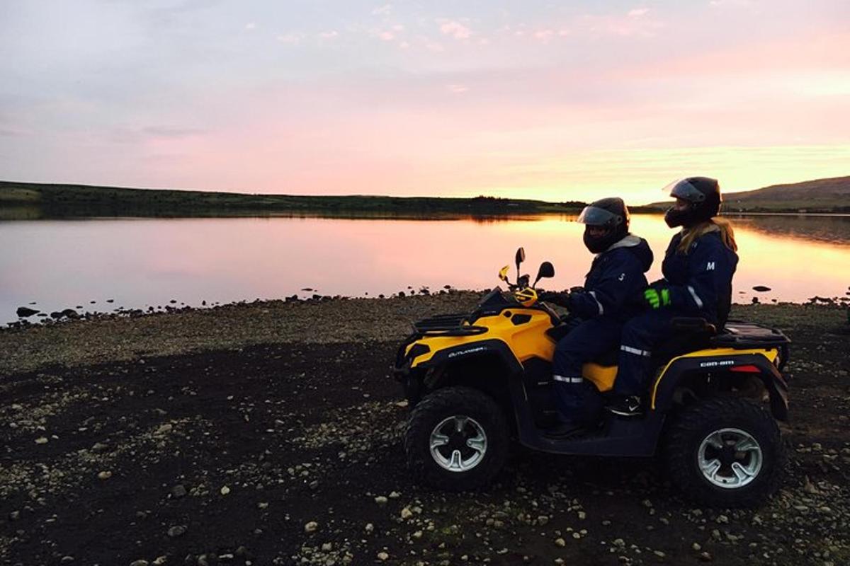 due persone sedute su un quad vicino a un lago