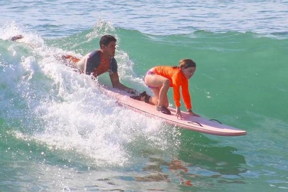 dva človeka jahata val na deski za surfanje v oceanu