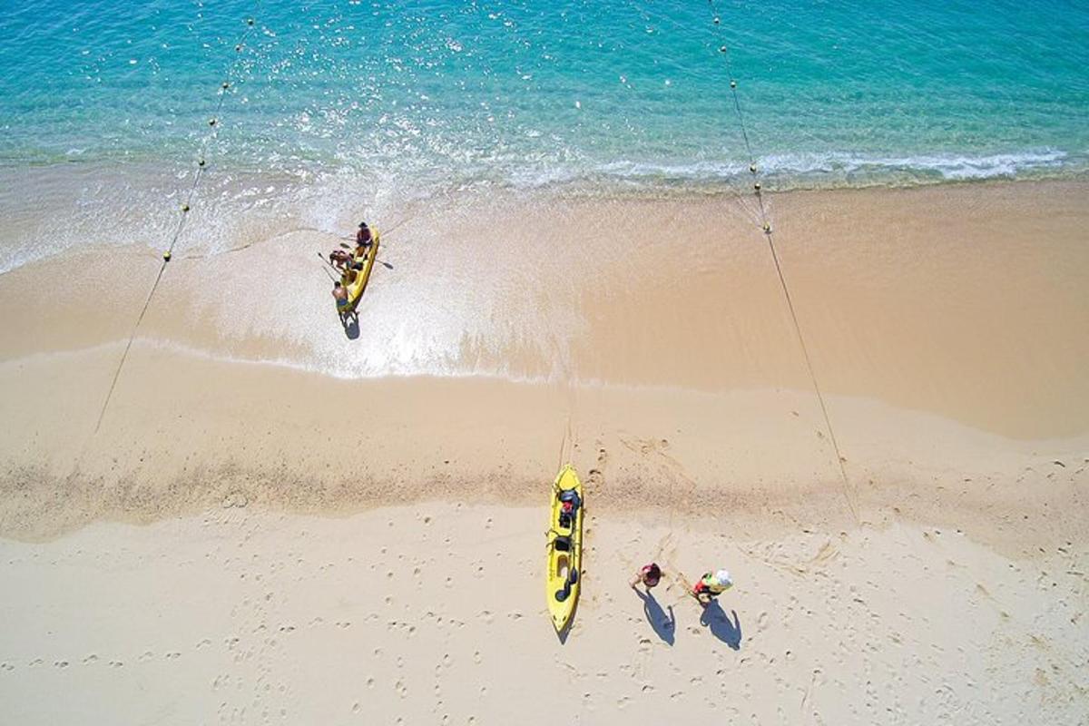 Trije ljudje stojijo na plaži ob oceanu
