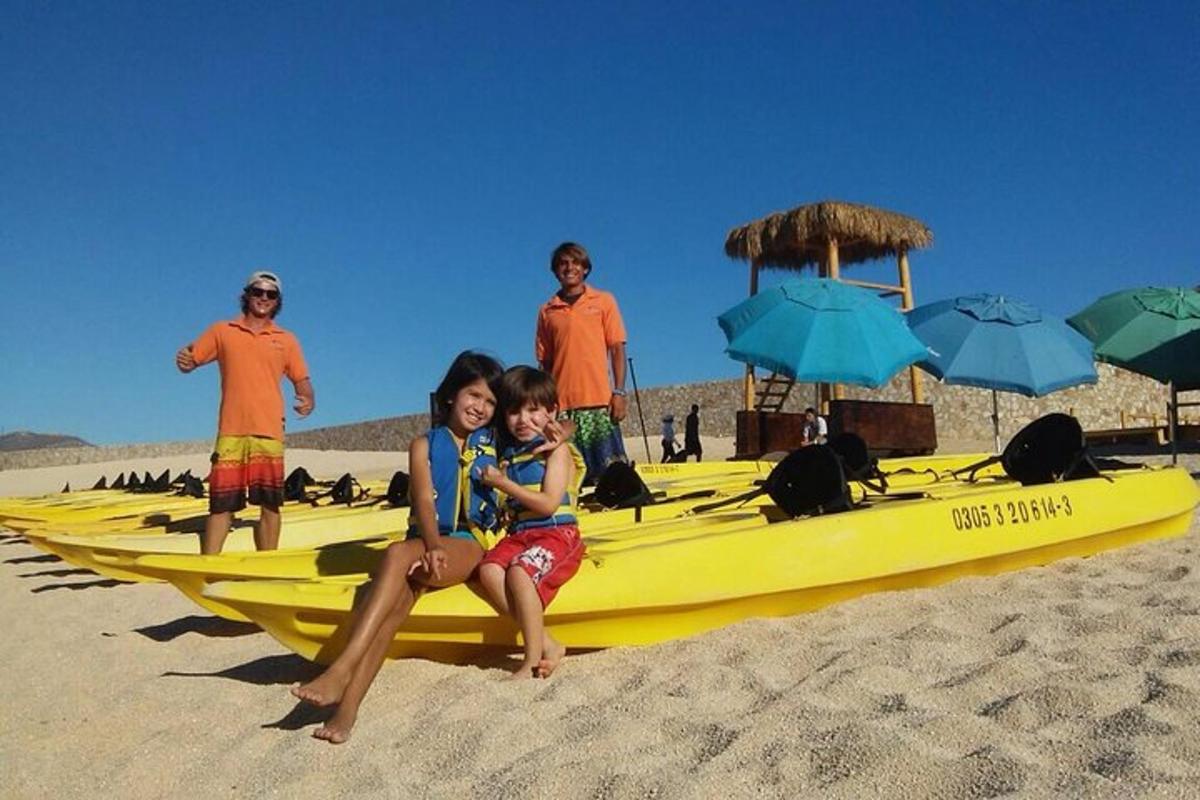 skupina ljudi, ki sedijo na rumenem kajaku na plaži