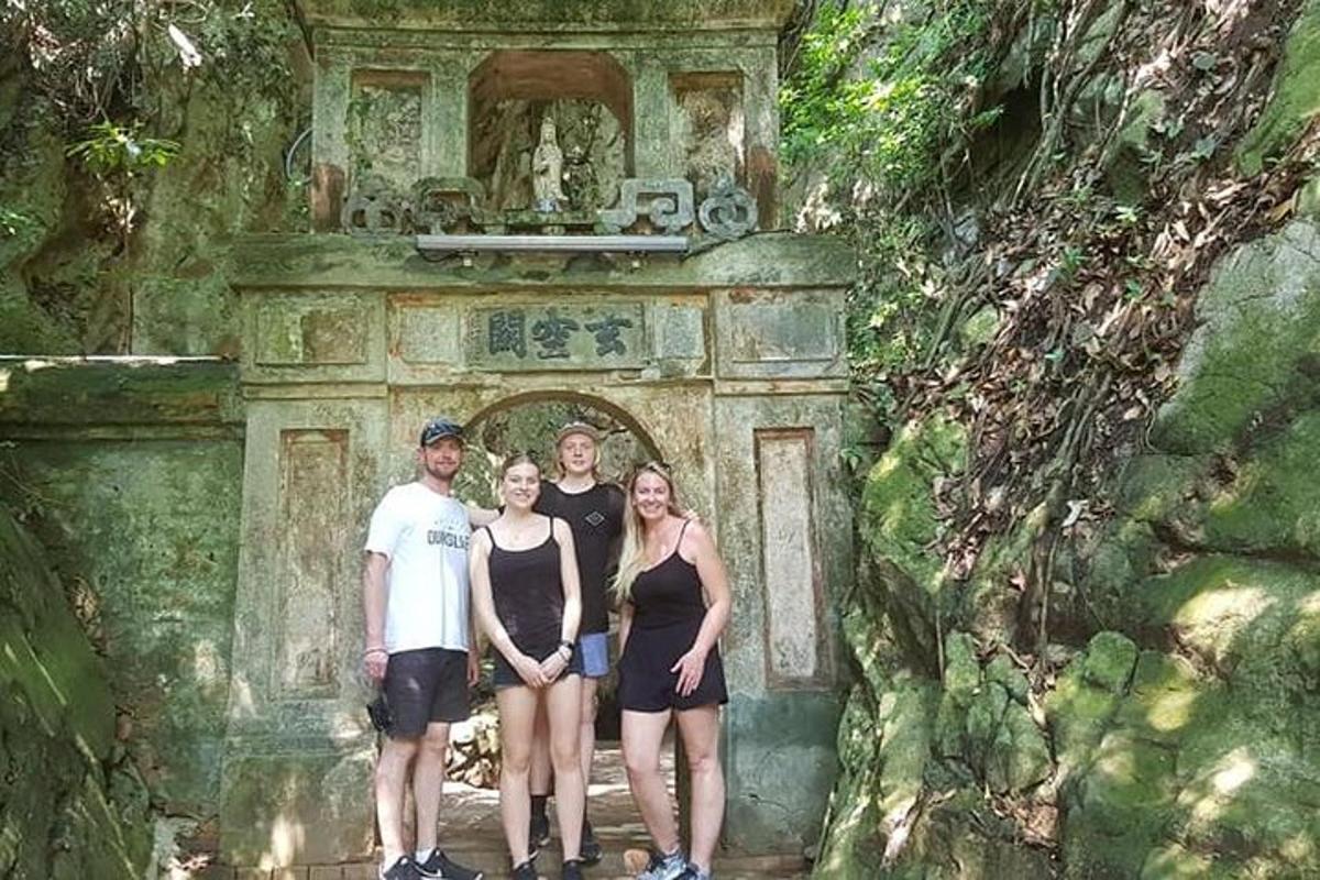 um grupo de pessoas em pé em frente a um arco de pedra