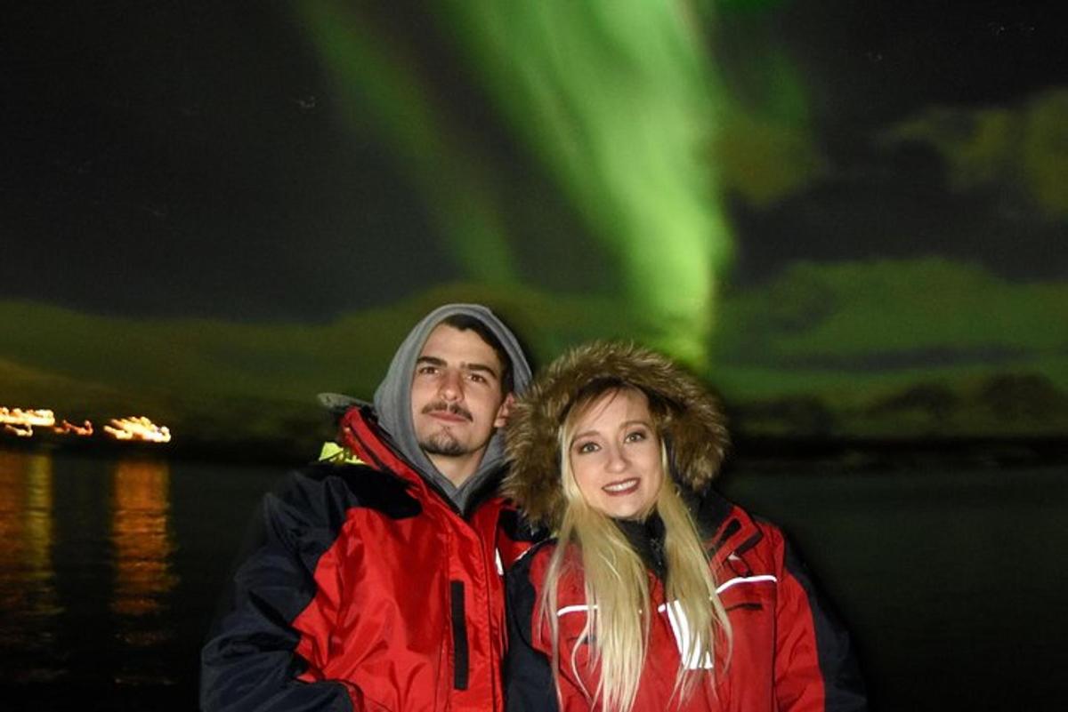 un uomo e una donna in piedi davanti all'aurora