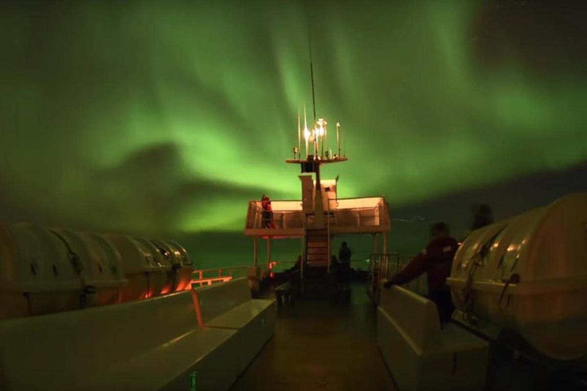 un'immagine di una nave con l'aurora boreale verde