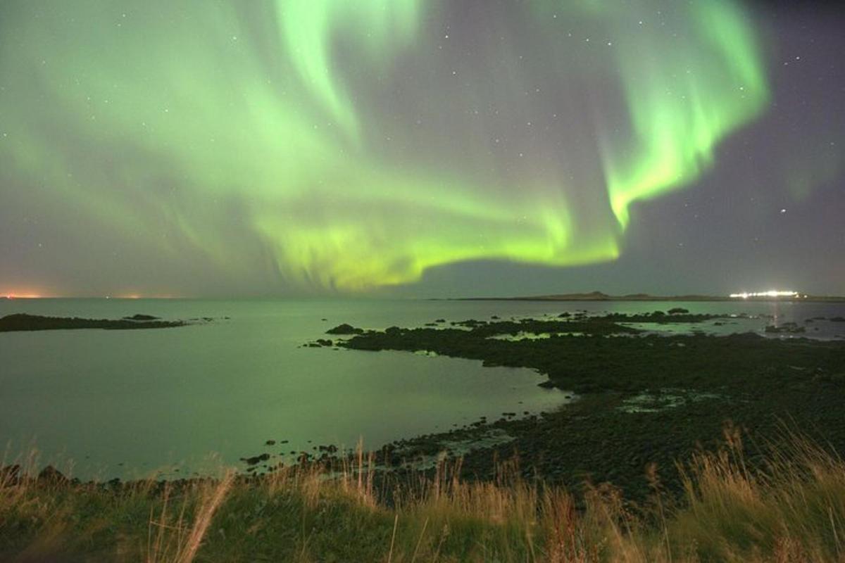 un'aurora sopra uno specchio d'acqua di notte