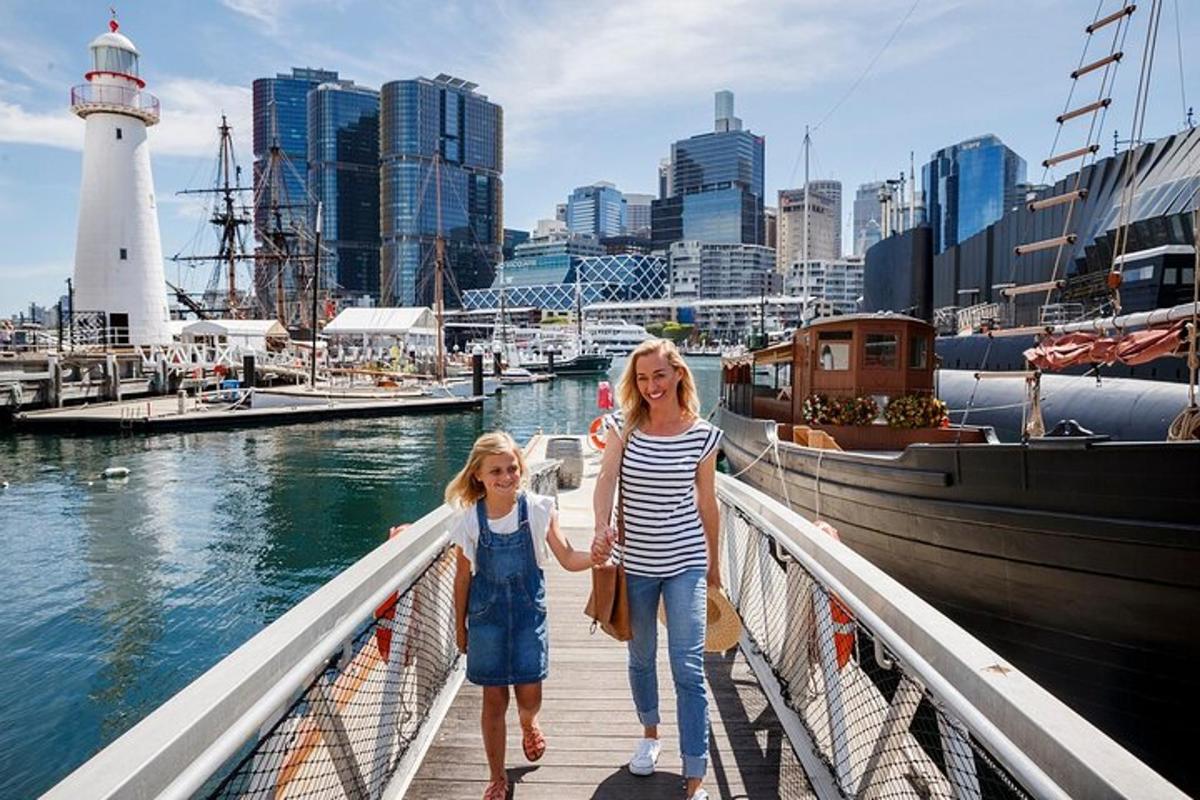 two girls walking on a bridge near a harbor