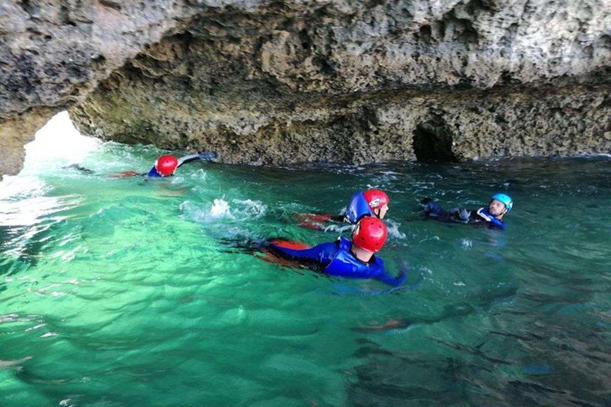 tiga orang di dalam air dalam sebuah gua