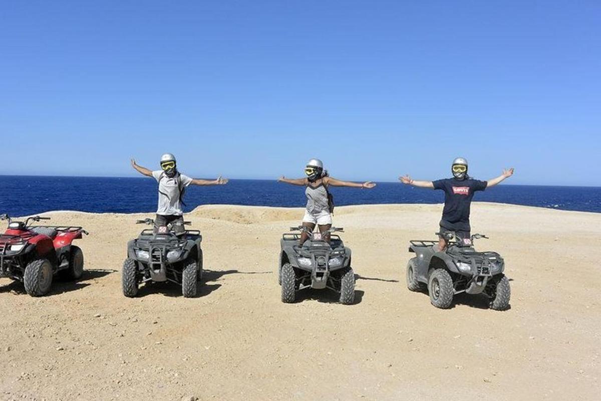 a group of three people on atvs on the beach