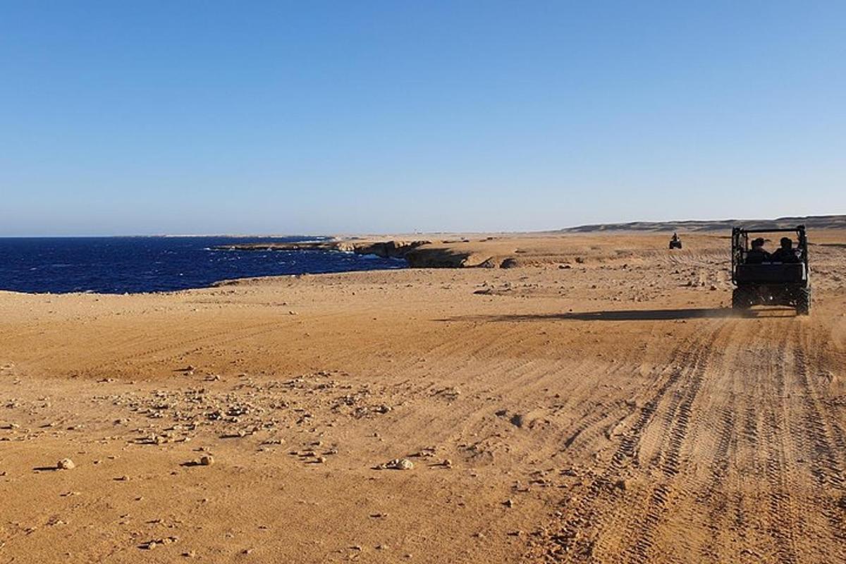 a truck driving on a dirt road near the ocean