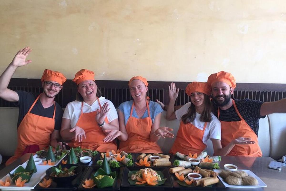 Un grupo de personas con delantales naranjas sentadas en una mesa con comida.