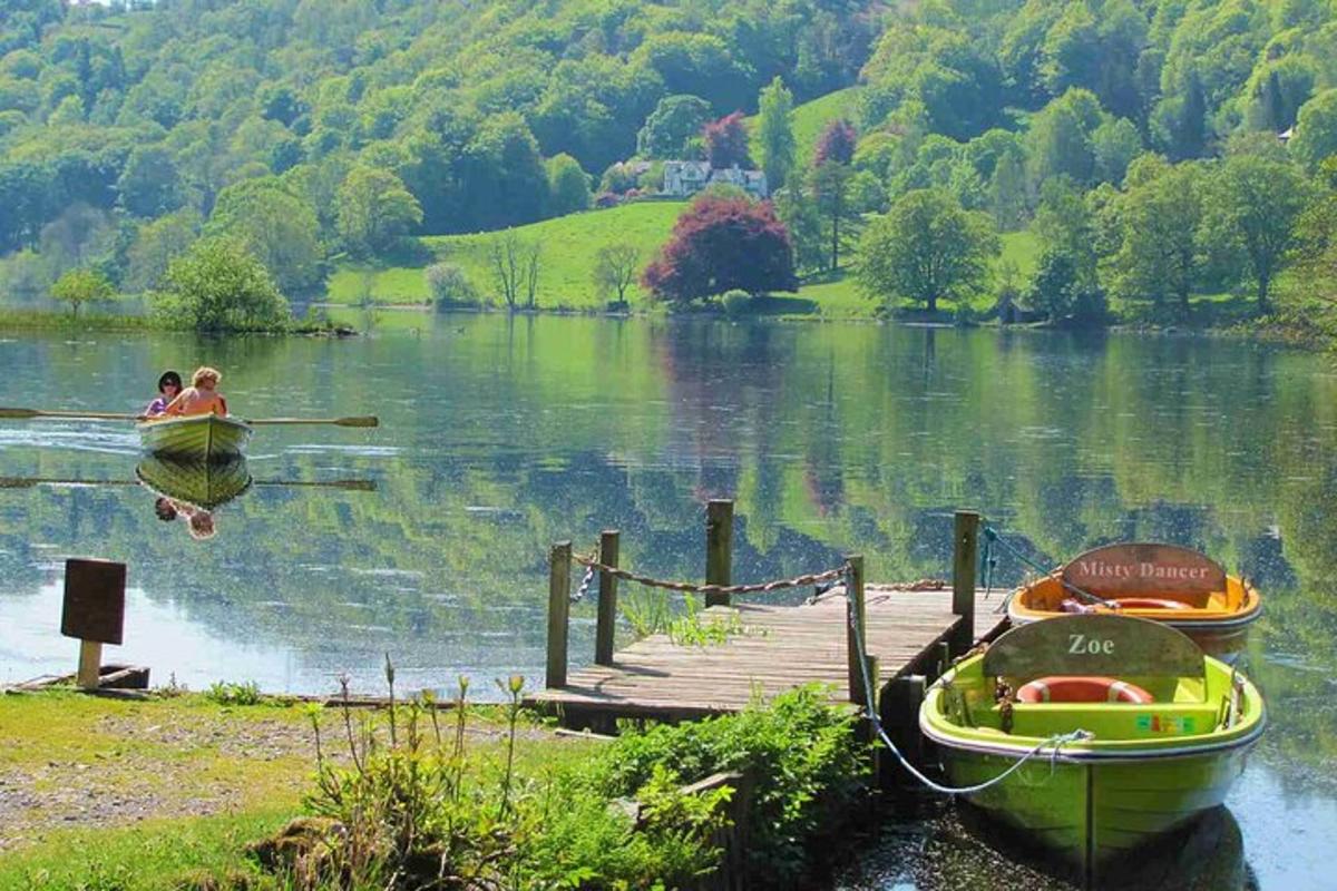 two people are rowing a boat on a lake