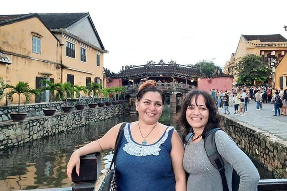 duas mulheres em pé ao lado de um rio em uma cidade