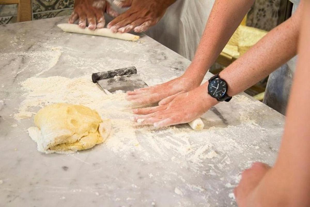 una persona che impasta una palla di pasta su un tavolo