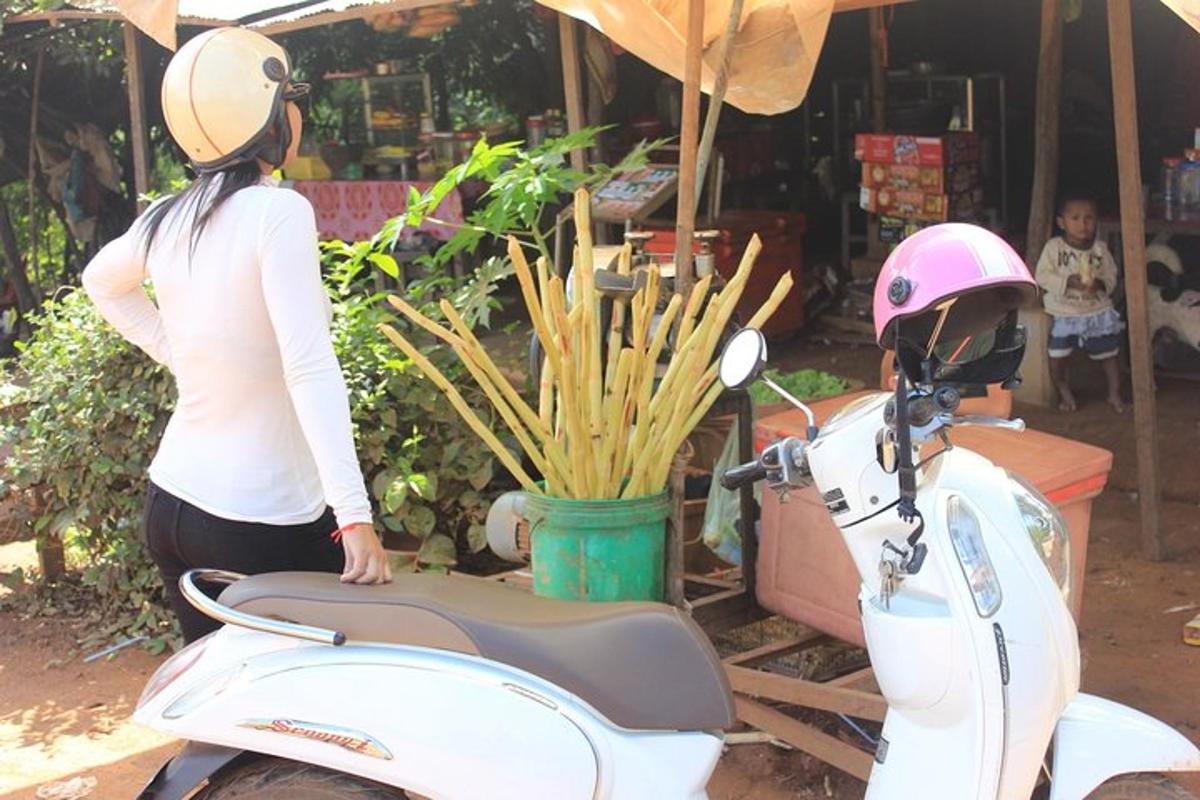 uma mulher está parada ao lado de uma scooter
