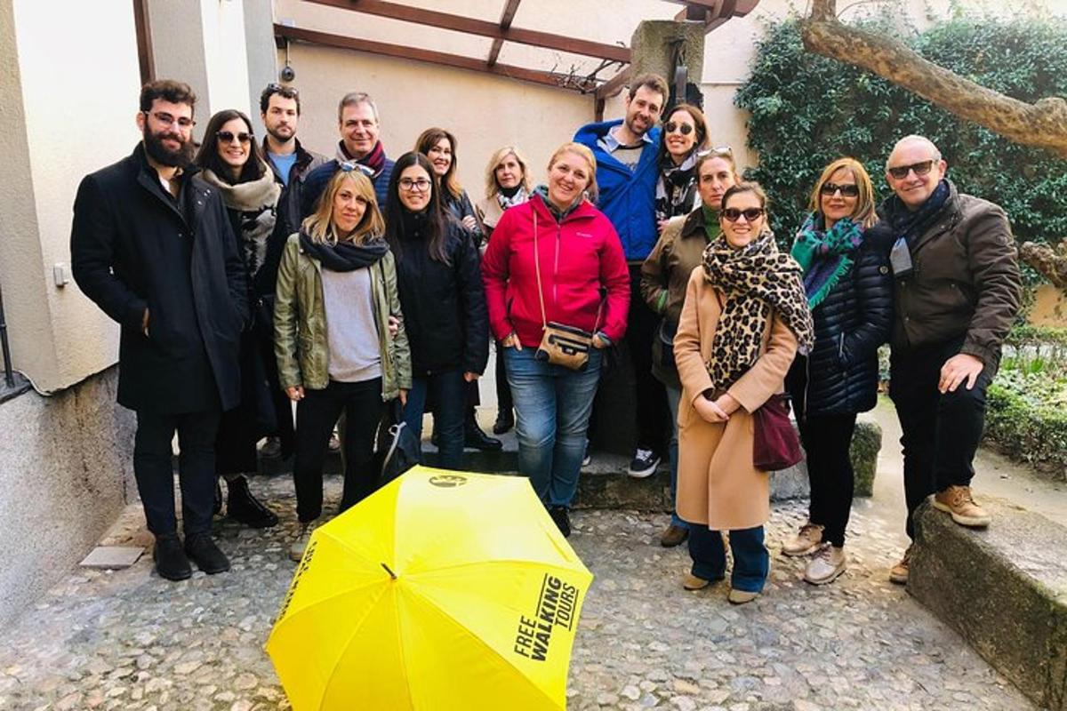 un gruppo di persone in posa per una foto accanto a un ombrello giallo