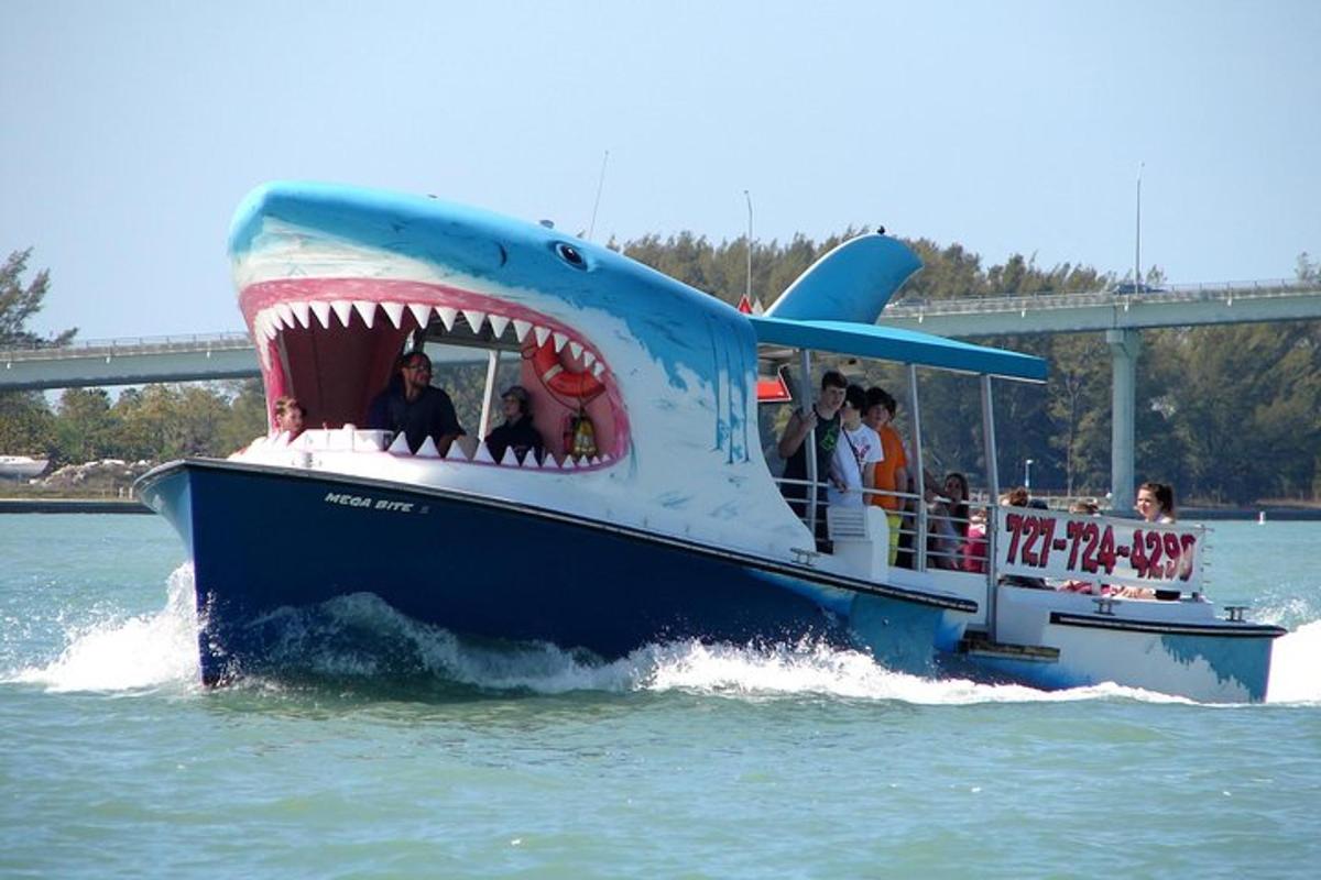 a blue boat with a large shark on the water