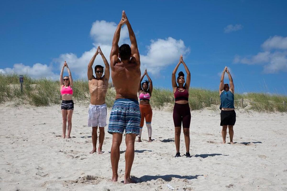 a group of people doing yoga on the beach